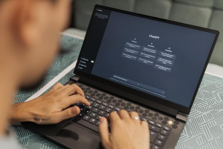 A person typing on a laptop that is showing the ChatGPT generative AI website.